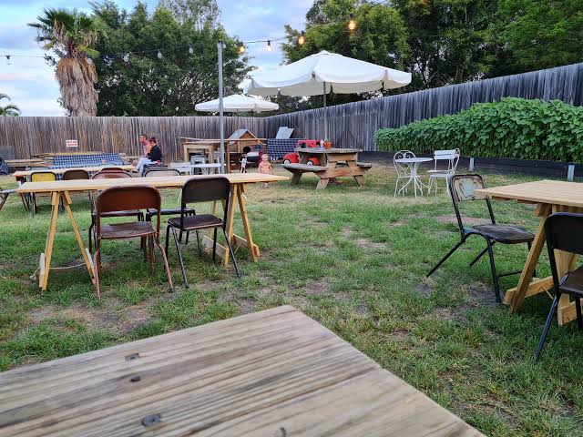 Whistlestop's outdoor garden dining area with picnic tables and market lights